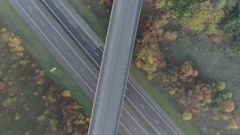 drone shot zooming in on overpass, mountainbiker riding over bridge