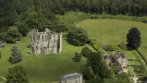 view over old wardour castle in a forest setting with bright green sunny fields