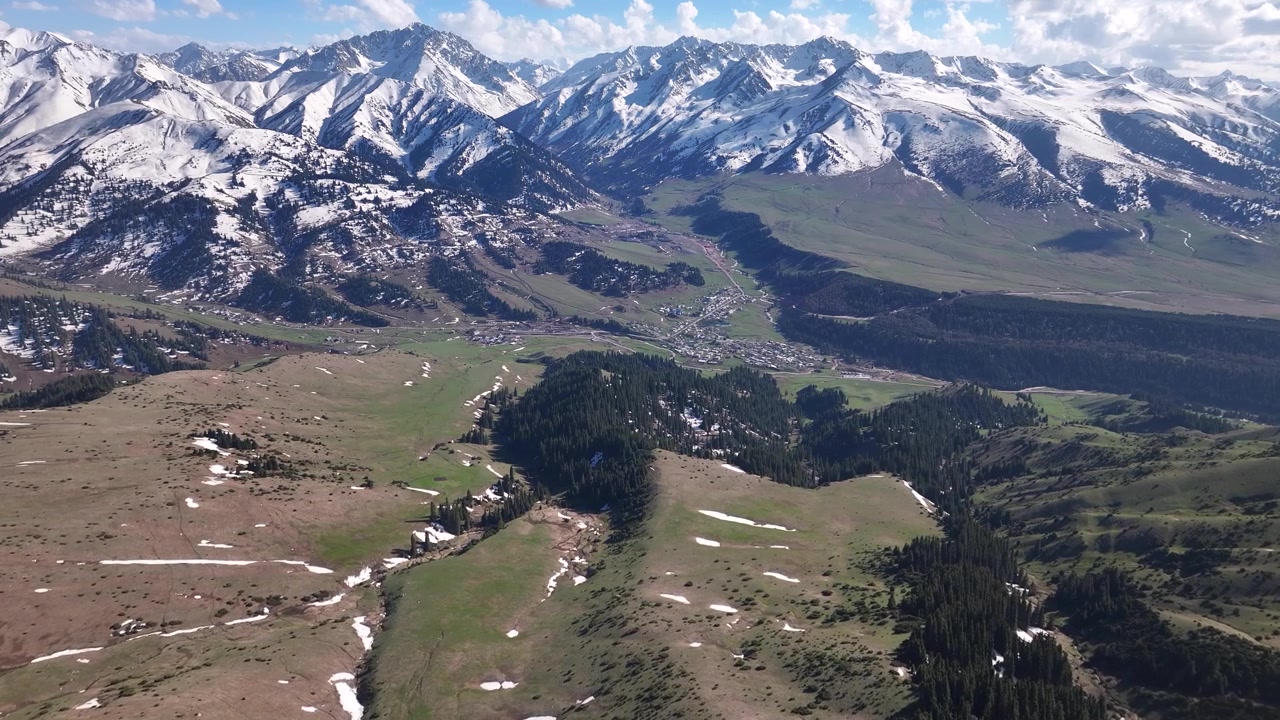 Paesaggio montano di Jyrgalan in Kirghizistan. Cime innevate e valle verde. Ripresa aerea con drone.