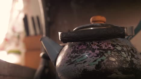 close up shot of steaming hot old teapot kettle in slow motion