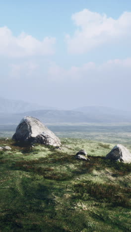 campo de hierba verde con montañas en el fondo