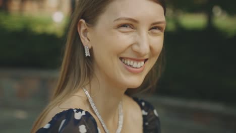 retrato de una mujer rubia feliz con una sonrisa brillante y cautivadora disfrutando al aire libre - toma de primer plano