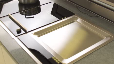 persona que ajusta los controles en una cocina de inducción moderna