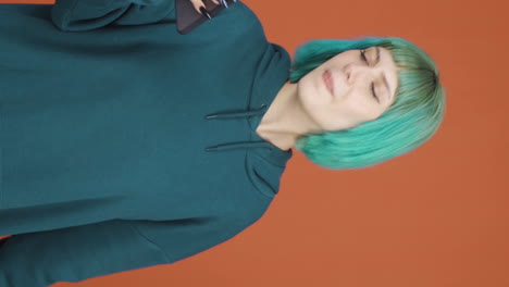 video vertical de una mujer joven bailando con el teléfono en la mano.