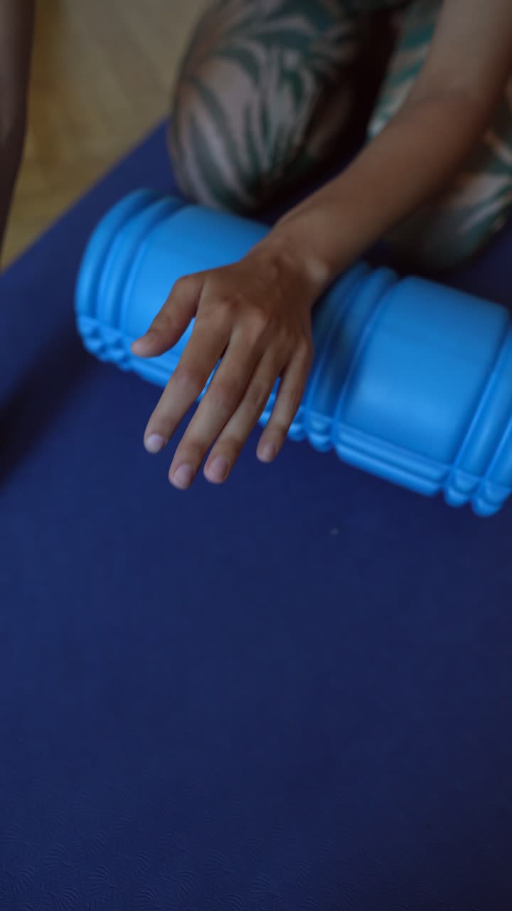 mujer usando un rodillo de espuma para estirar el brazo