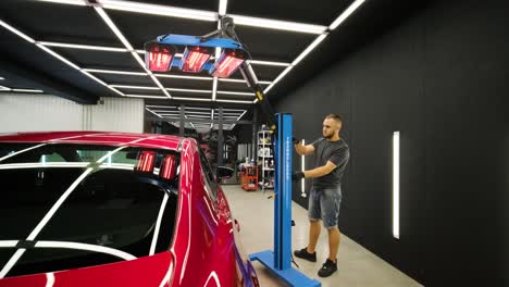 red lamps for drying the ceramic coating are behind car