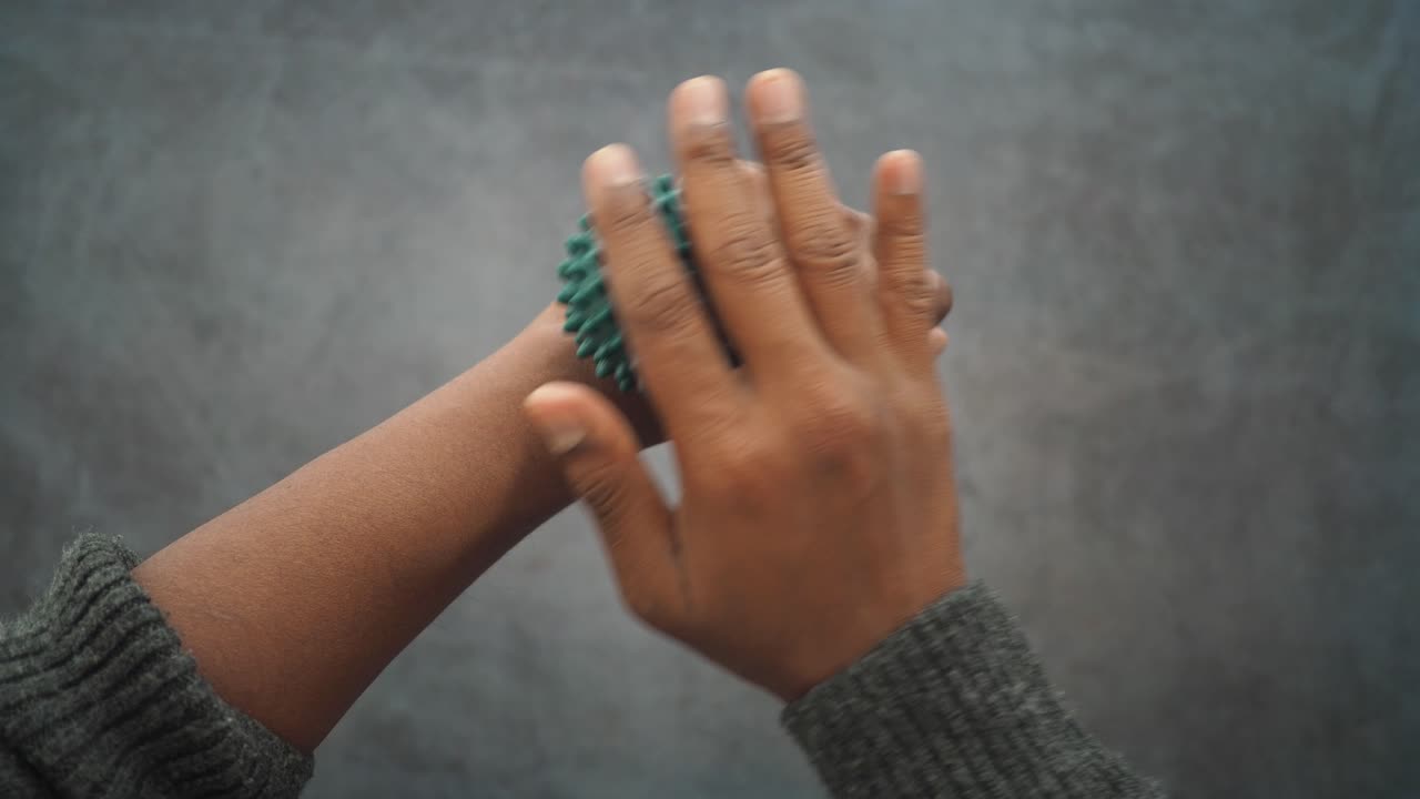 Person Massaging Wrist with Spiky Massage Ball