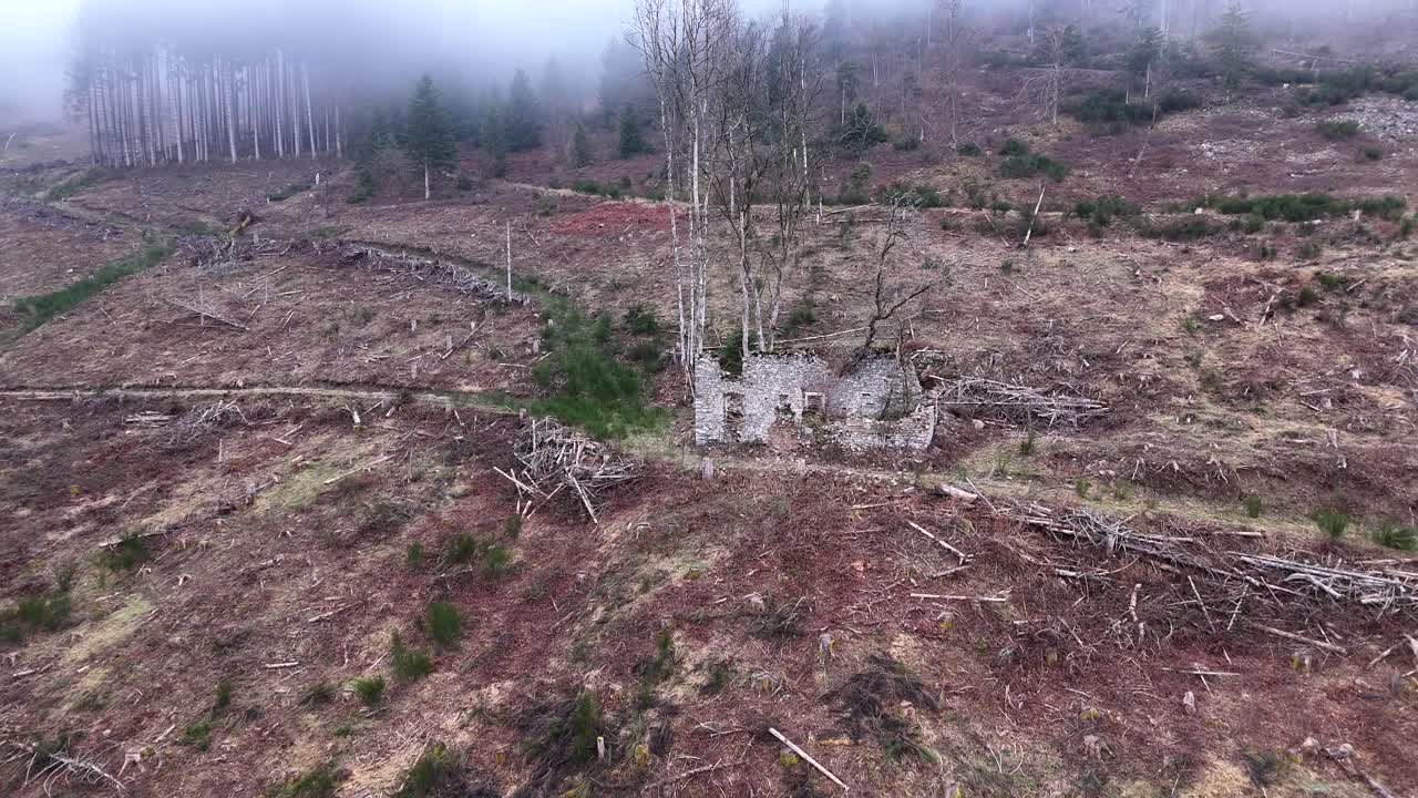 Aerial rocket fly above very old farm ruins on a mountain with forest and fog