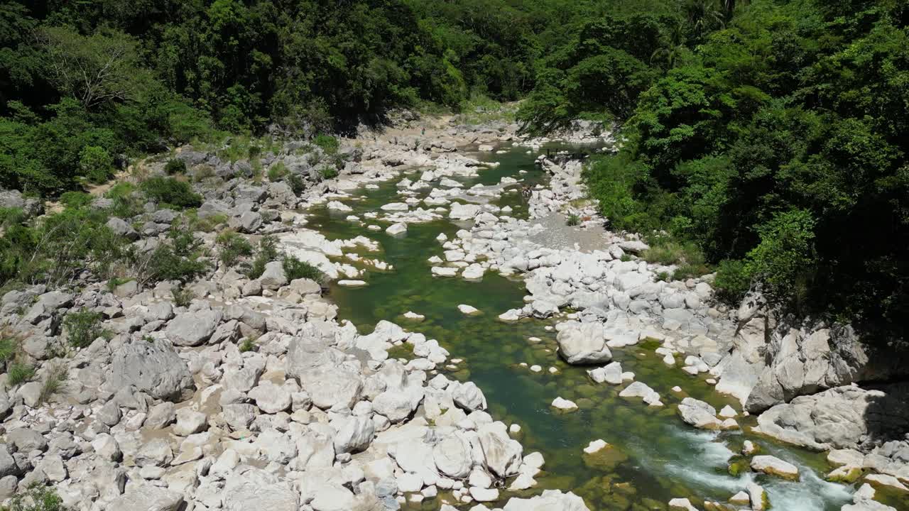 Slow forward movement with a slight rotation shows the river’s length and surrounding plants, capturing the expansive nature of Tinipak River, Philippines
