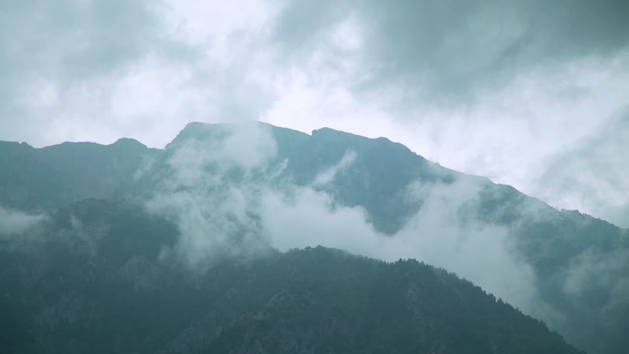 day shot of mountains peak with fog green mountains top fog and grey clouds in the sky magic nature view