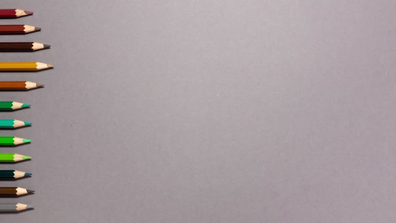 Wooden colored pencils flat lay on gray background with copy space