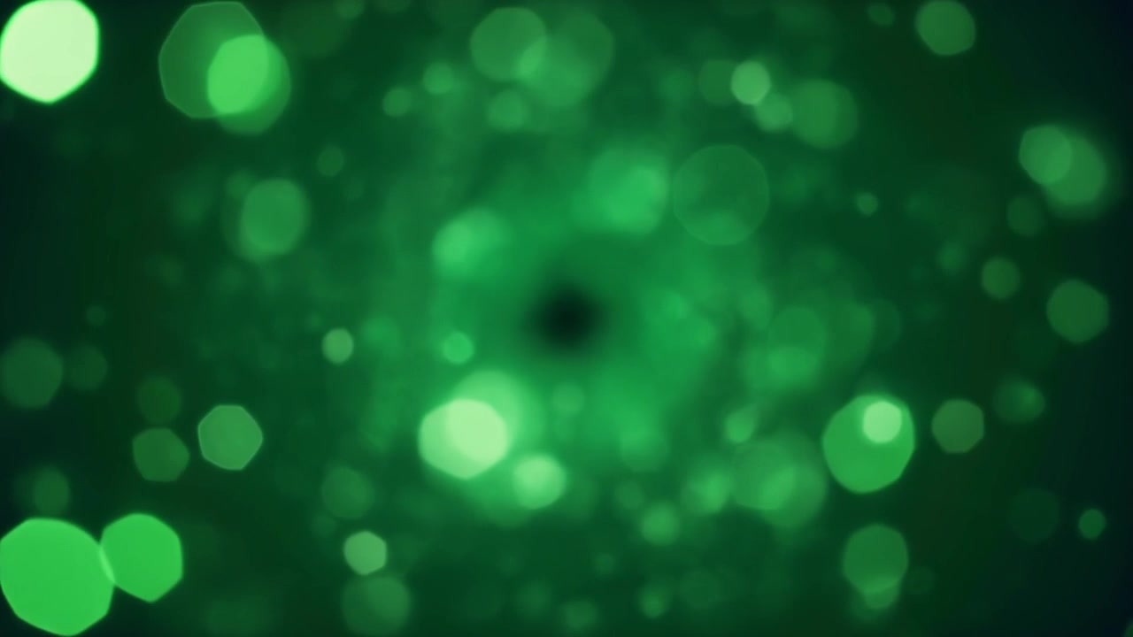 Abstrakte grønne bokeh-lyspartikler flydende i mørk baggrund
