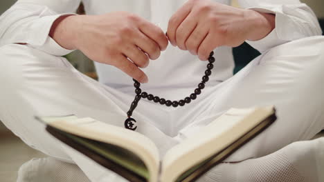 muslim man engaged in prayer with tasbih and quran