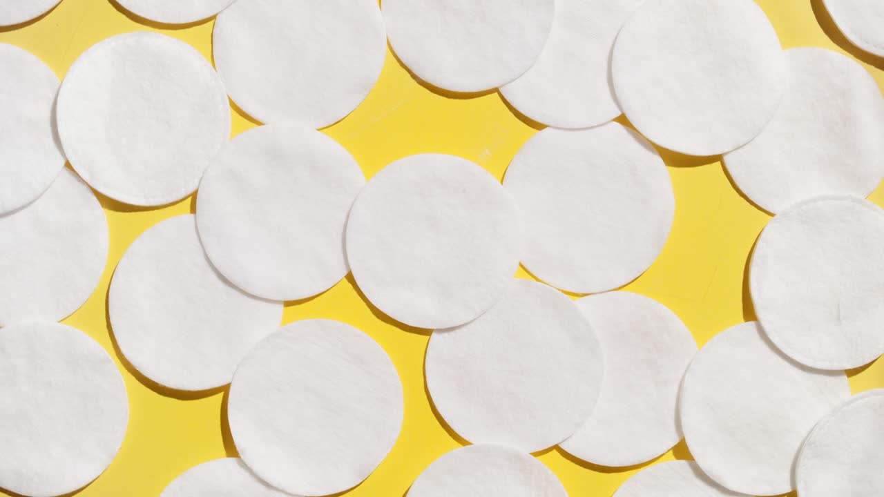 물 표면에서  반지를 만들고 노란색 bg에 목화 패드 위에 놓습니다.