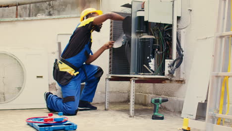 mechanic sweeps debris in condenser