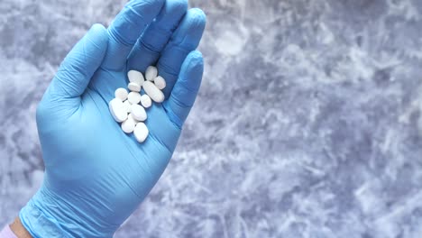 con guantes de mano sosteniendo pastillas