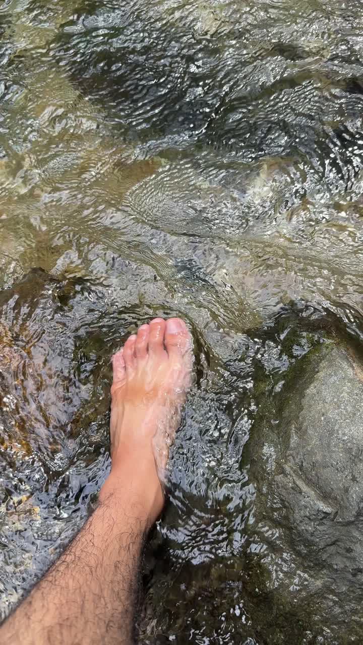 Close-up of Foot in Cool Flowing River Water