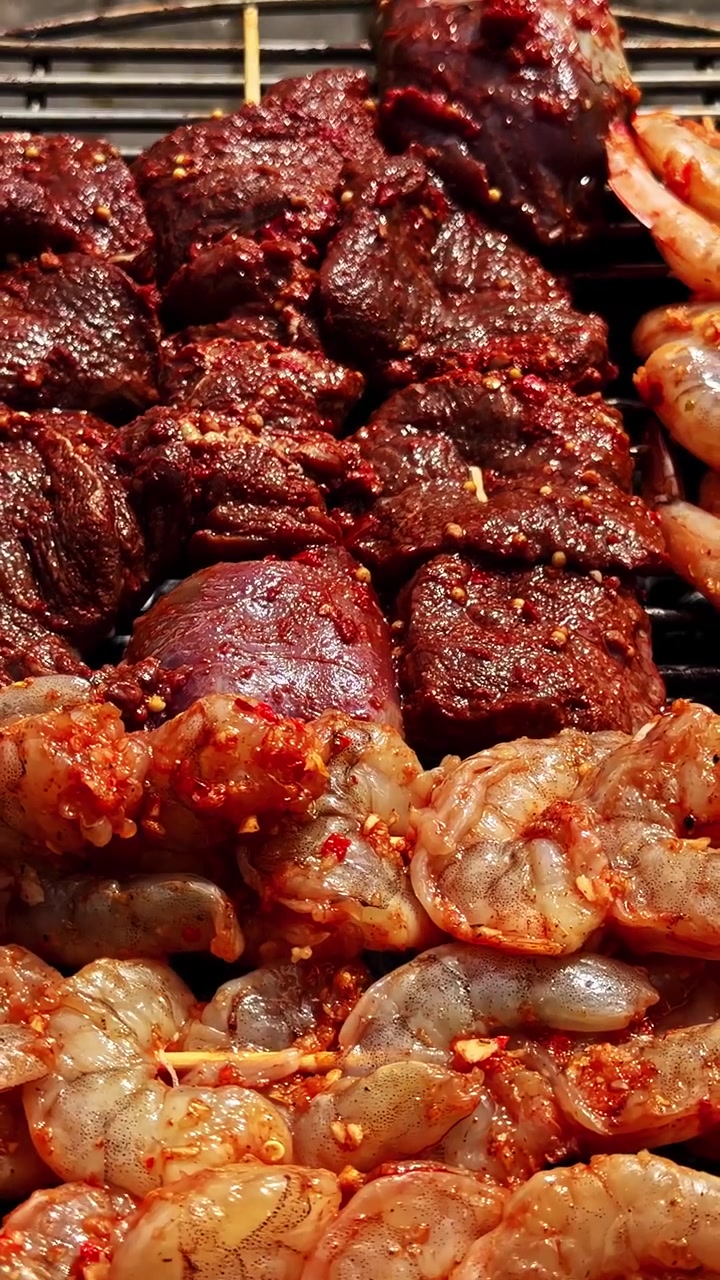 Makanan laut sedang dimasak dan dipanggang di atas panggangan barbekyu terbuka di luar ruangan, jarak dekat, warna-warna cerah