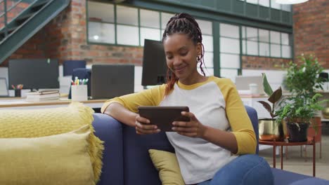 Happy-african-american-businesswoman-using-tablet-at-office