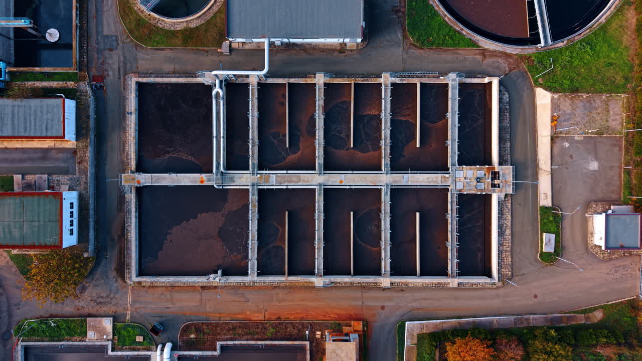 Person walks around the huge basin of waste water. Sewage treatment plant from drone footage
