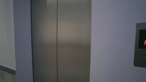 elevator panel with floor indicator near a clean hospital hallway with bright light.