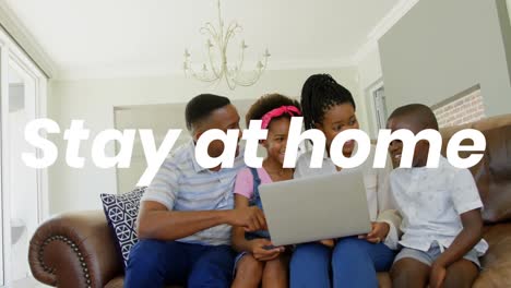 familia afroamericana usando una computadora portátil en casa con las palabras quedarse en casa