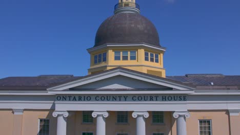 drone rise to the gold statue on the front part of the ontario county courthouse in canandaigua, new york near canandaigua lake