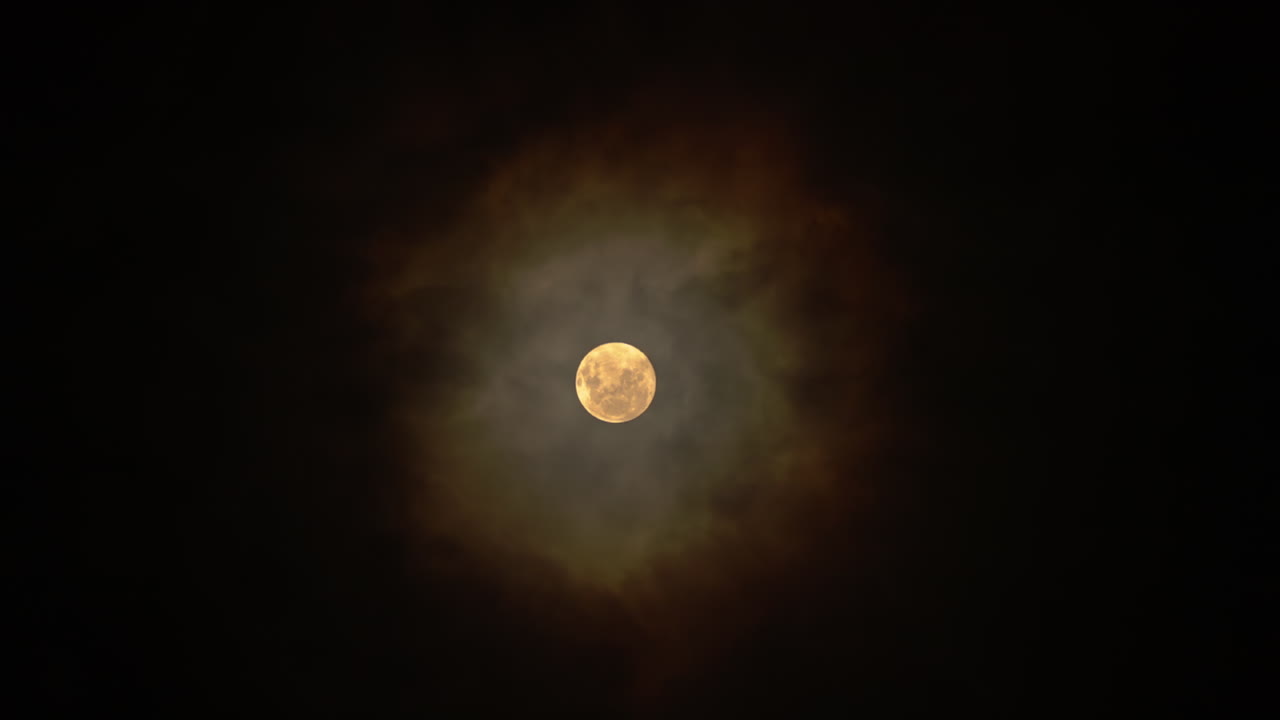 밤에 폭풍에 의해 불어나는 구름과 함께 반이는 노란 달