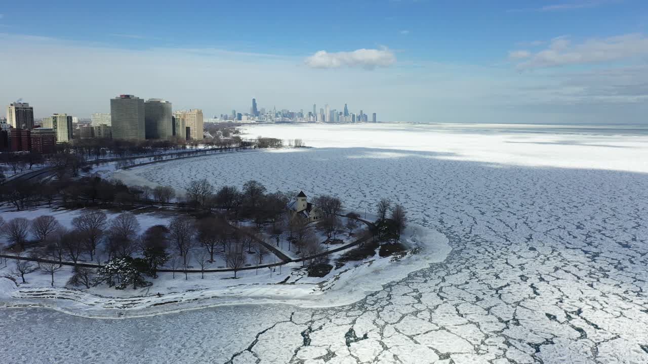 vista aérea sobre o gelo e o ponto do promontório com o horizonte de chicago ao fundo, ensolarado, dia de inverno em illinois, eua - reverso, tiro de drone