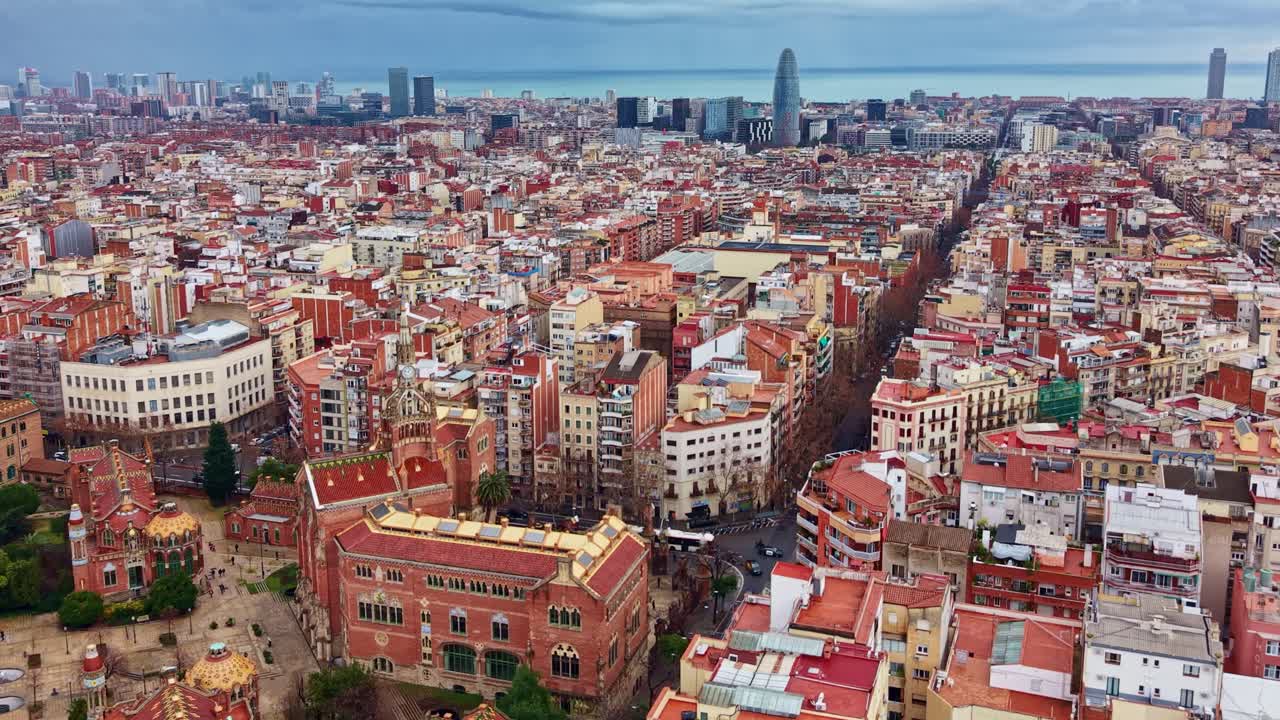 Drone flight advancing over Barcelona cityscape toward Torre Glòries or Agbar Tower