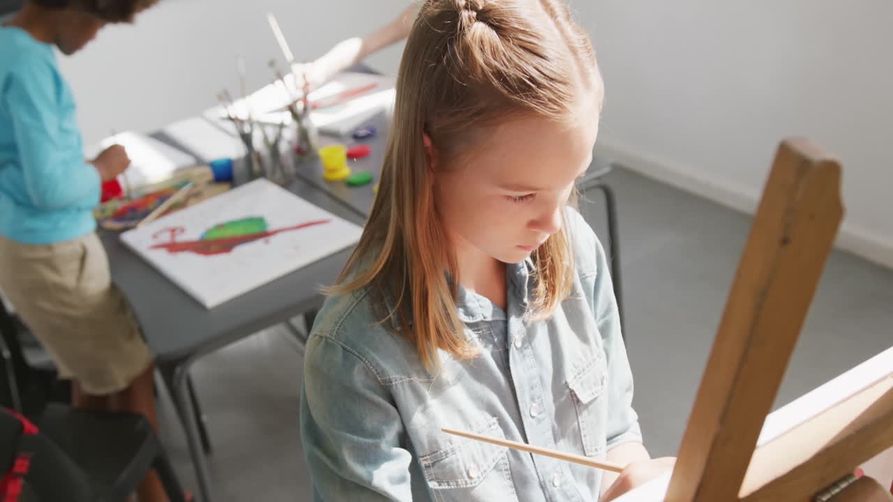 미술 수업에서 스 페인팅에 집중하는 백인 여학생의 높은 각도 비디오, 복사 공간