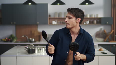 hombre enérgico tocando el tambor con utensilios de cocina