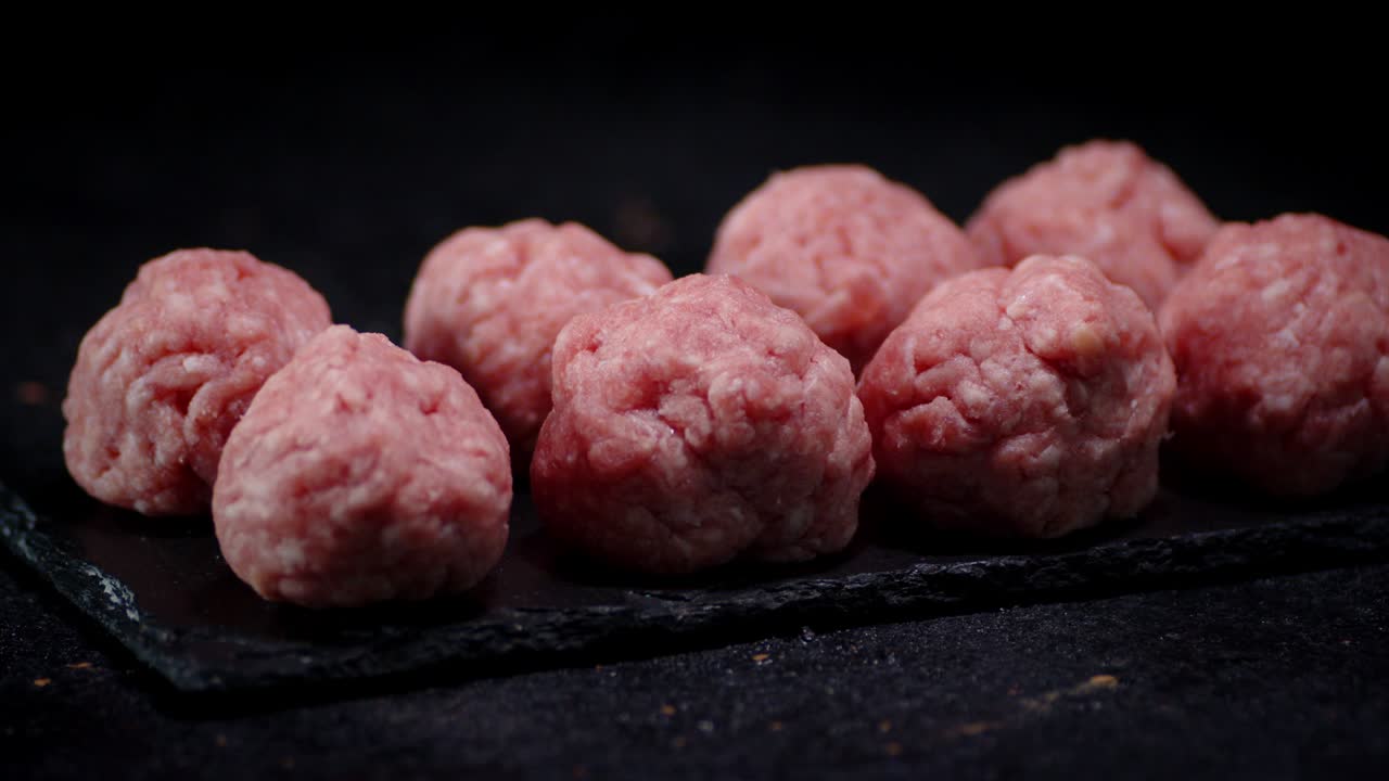 las albóndigas crudas hechas de carne molida fresca giran lentamente.