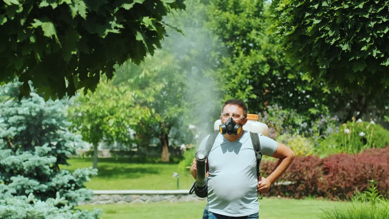 생태적 살충제를 스프레이합니다. 농부는 보호 마스크와 안경으로 나무와 관목을 흡수합니다. 정원사는 정원을 유지합니다.