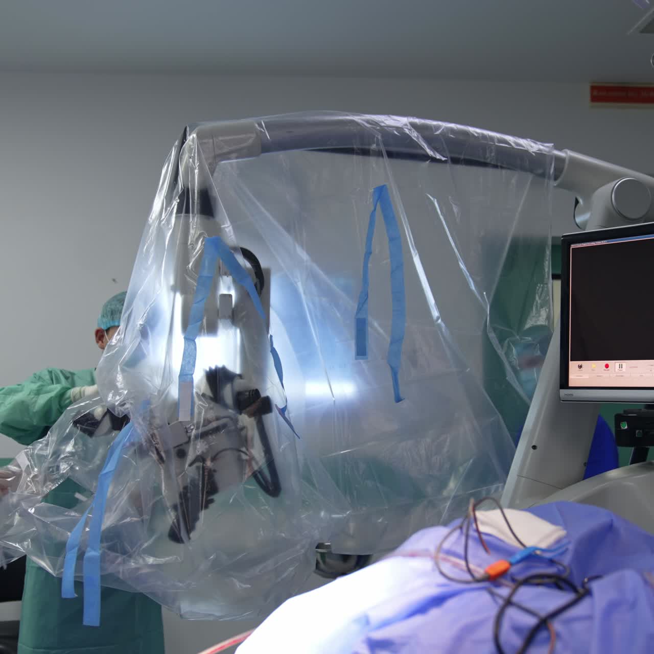 Medics covering the high-precise microscope in plastic. Preparing modern equipment for usage at neurosurgical operation