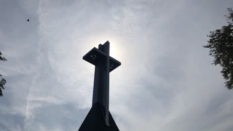 metal cross against cloudy sky