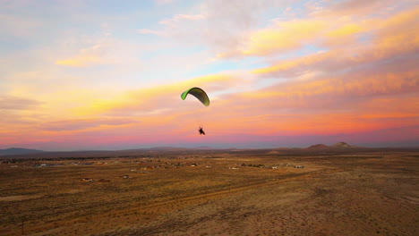 flying alongside a powered paragliding pilot during a colorful sunset above the mojave desert