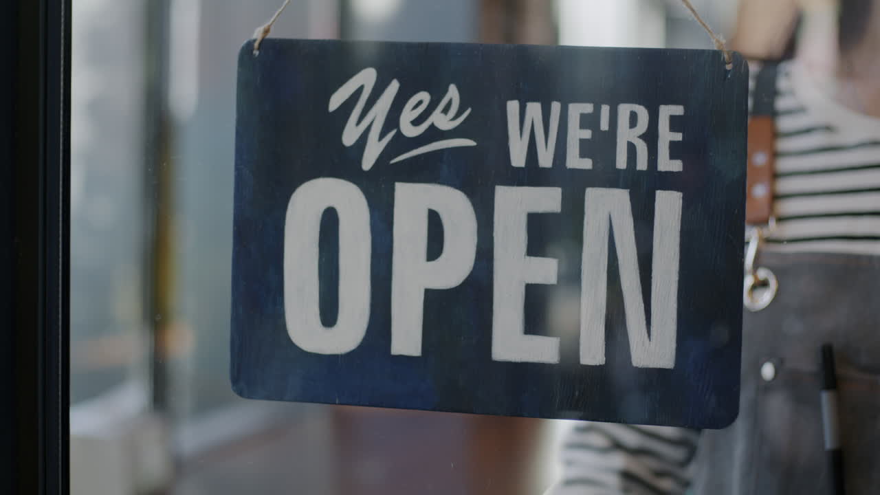 Business Opening - Woman Hanging Open Sign