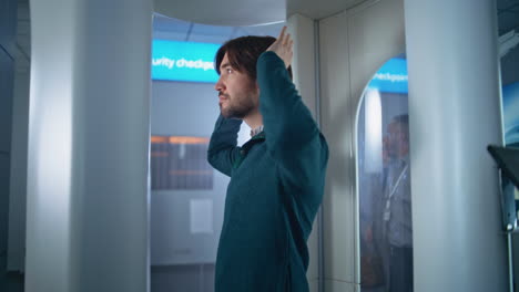 hombre pasando por el puesto de control de seguridad del aeropuerto