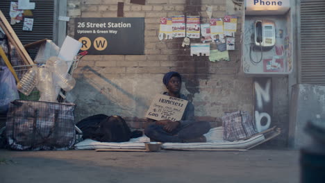 Homeless Man Holding Cardboard Sign, Accepting Donations from People on Street