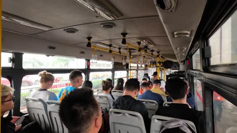 pasajeros escuchando a un guía en un recorrido en autobús