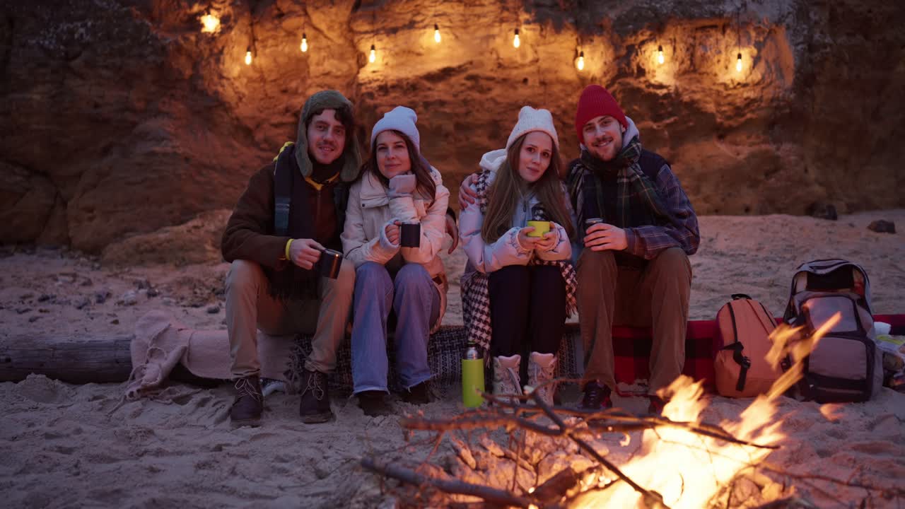 Friends enjoying a campfire on a beach at night