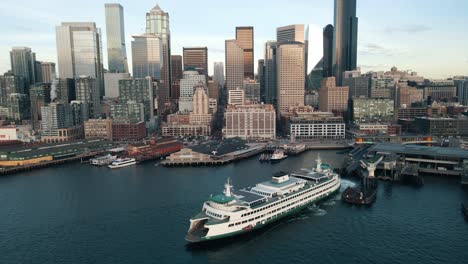 el ferry de seattle y el horizonte se revelan al atardecer mientras el dron se retira para revelar la metrópolis panorámica.