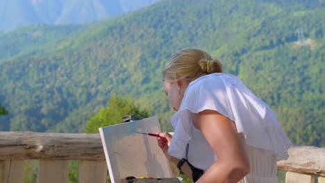 woman painting outdoors in mountains