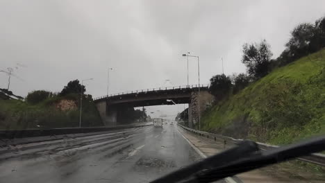 conducir por una carretera mojada en un día lluvioso con los limpiaparabrisas en movimiento