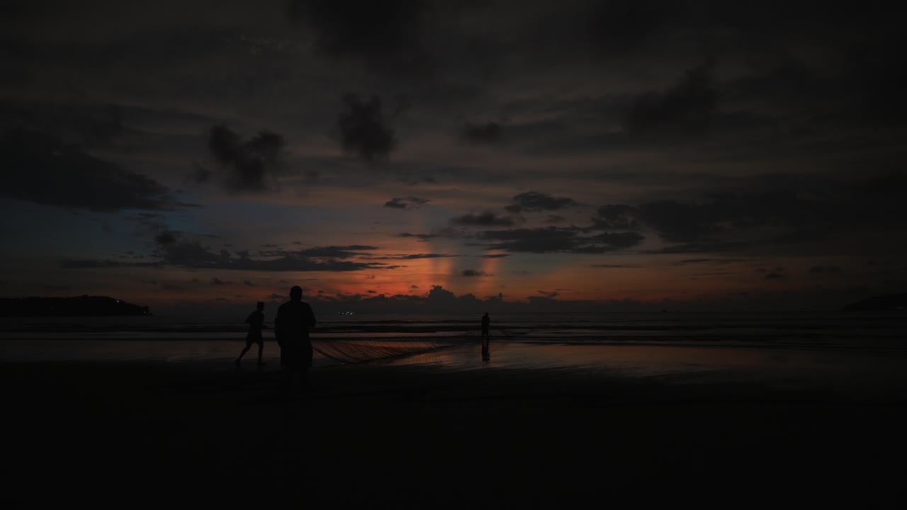 구름이 지나가는 아름다운 일몰 동안 해안을 걷는 사람들과 잔잔한 물이 있는 호수의 정적 저속 촬영