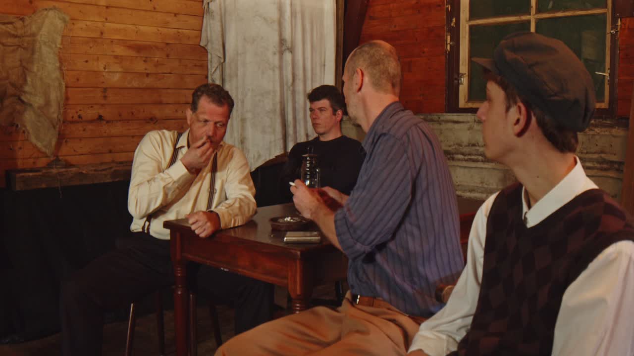 Dolly of a young kid asking an older smoking man for his first cigarette