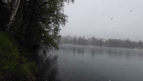 Huge-Snow-Flakes-Fall-on-Lake-with-Clear-Turquoise-Water-with-Camera-going-under-Water