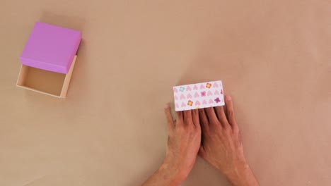 gluing handmade wrapping from decorative paper for cardboard gift box