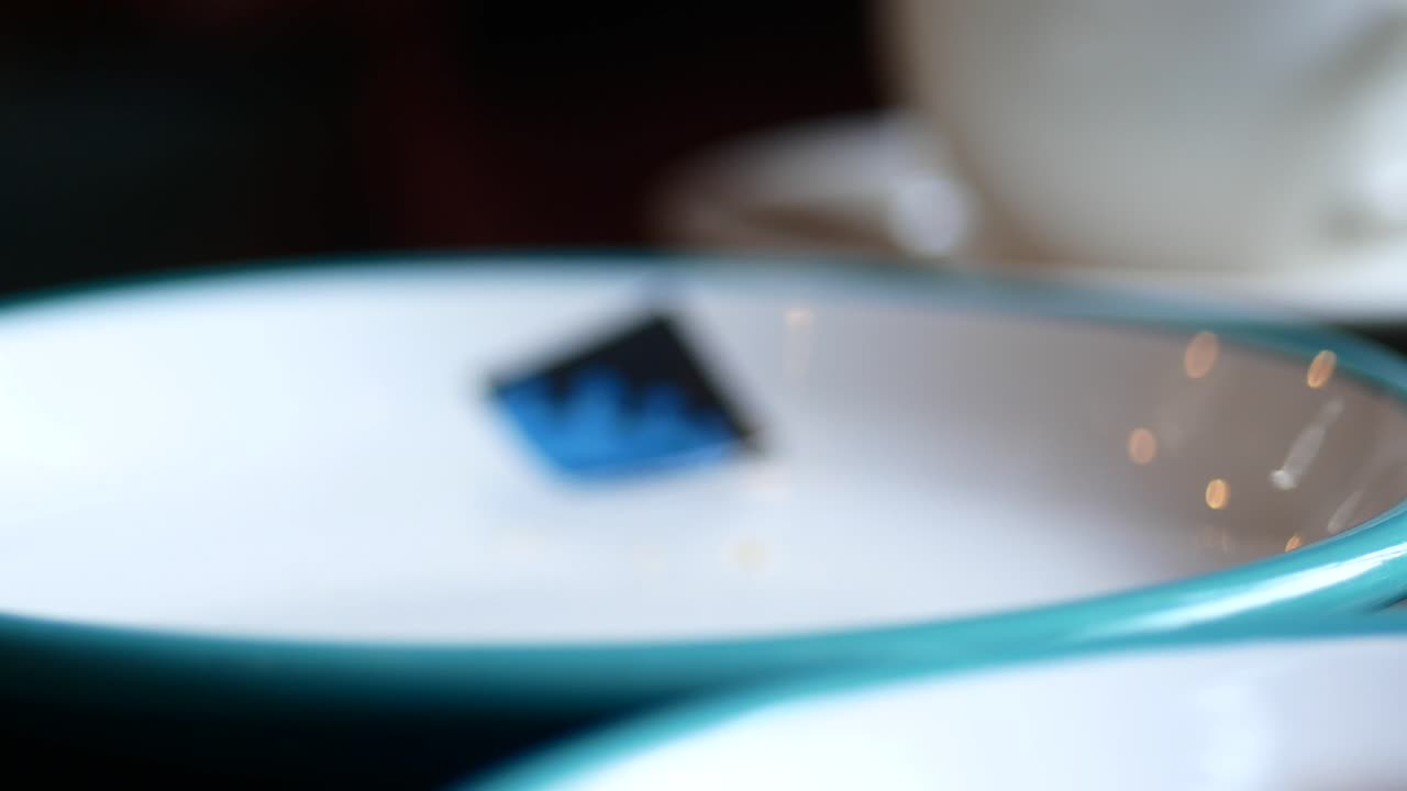 뒷면에 커피 한 잔이 있는 접시 위에 있는 크로아산에 손을 는 여자의 클로즈업입니다.